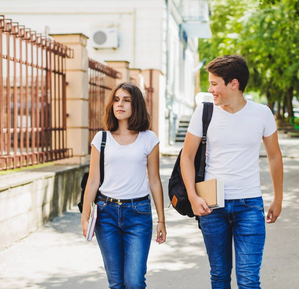 dos jovenes yendo a estudiar